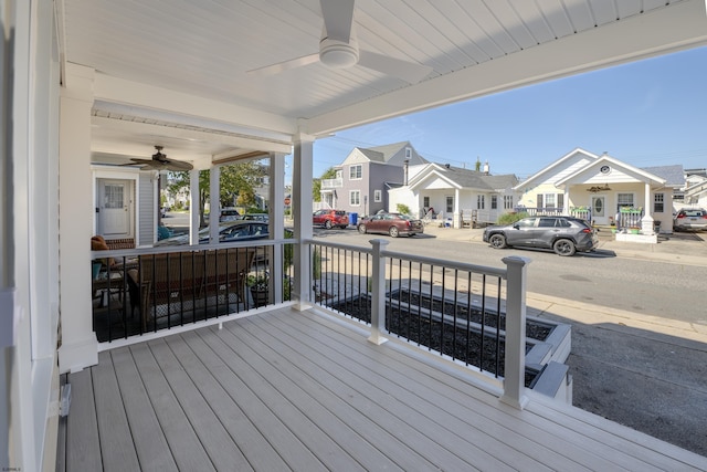 deck featuring a porch, a ceiling fan, and a residential view