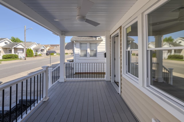 wooden terrace with a residential view, visible vents, covered porch, and ceiling fan