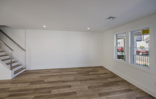 interior space featuring recessed lighting, wood finished floors, visible vents, baseboards, and stairs