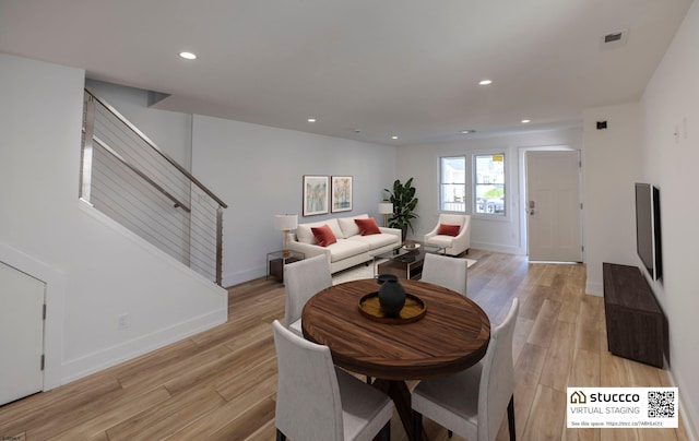 dining space with light wood-type flooring, baseboards, recessed lighting, and stairway