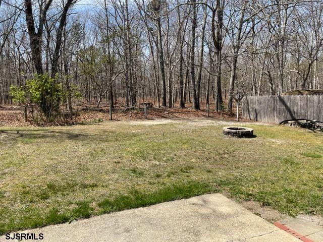 view of yard featuring a fire pit and fence