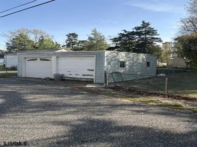 detached garage featuring fence