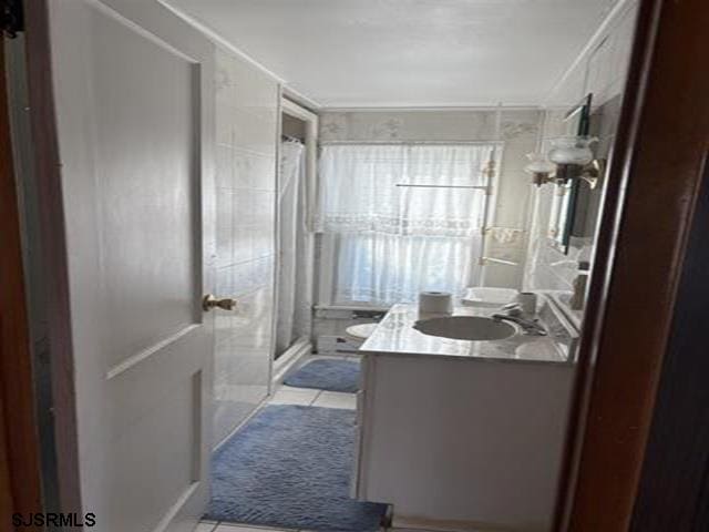 bathroom with vanity, tile patterned flooring, and a stall shower