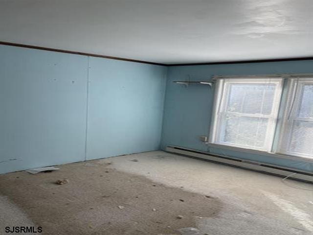 unfurnished room with a baseboard radiator