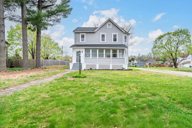 traditional home featuring fence, a shingled roof, and a front yard