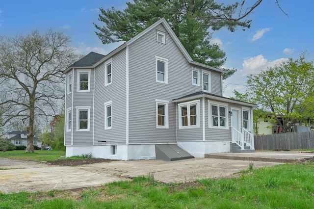 back of house with entry steps and fence