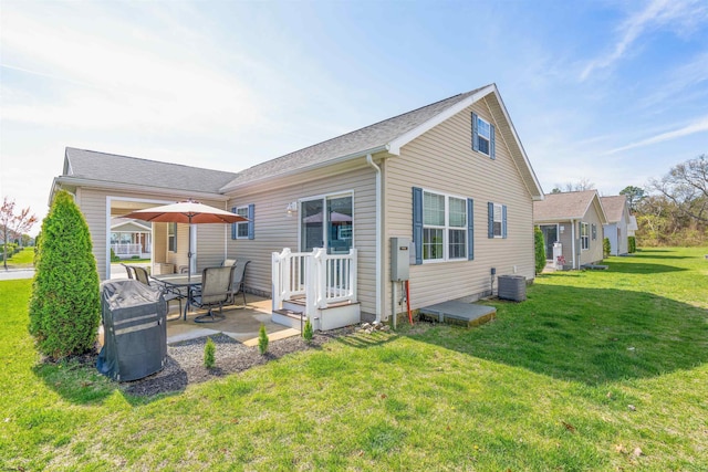 rear view of property with a yard, a patio, and central AC unit