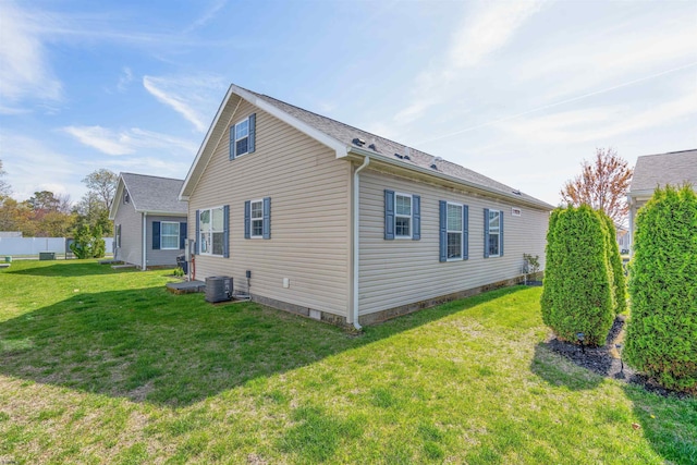 rear view of house featuring fence, a yard, and central air condition unit