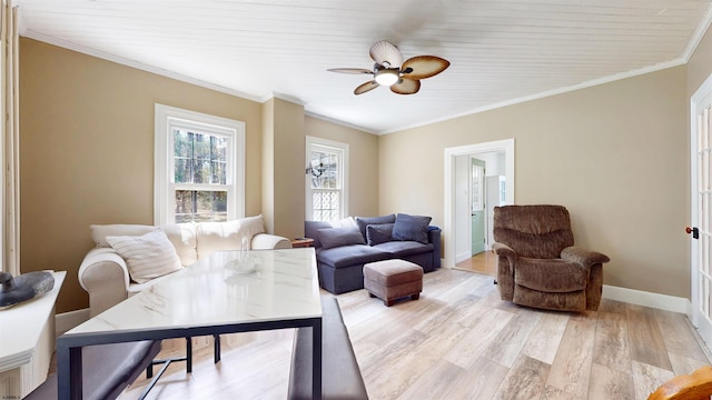 living area with ceiling fan, baseboards, ornamental molding, and light wood finished floors
