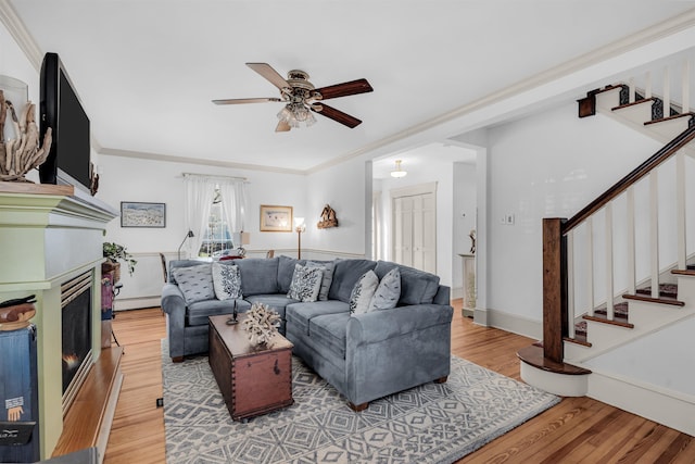 336 E Seabright Rd, Ocean City, NJ 08226 - living area featuring a glass covered fireplace, a ceiling fan, wood finished floors, stairway, and a baseboard radiator