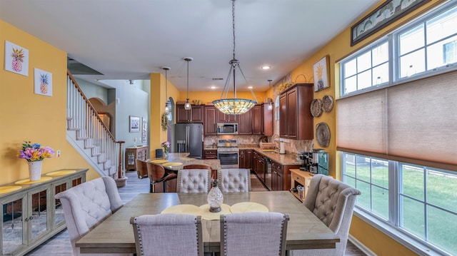 dining room featuring stairway, recessed lighting, wood finished floors, and plenty of natural light