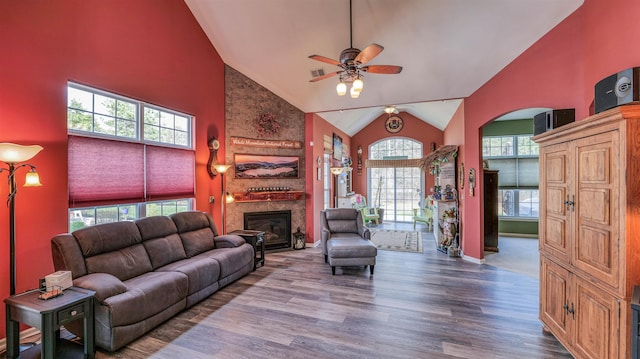 living room featuring a wealth of natural light, a ceiling fan, and high vaulted ceiling