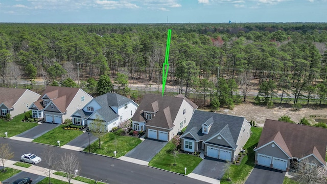 birds eye view of property featuring a residential view and a wooded view