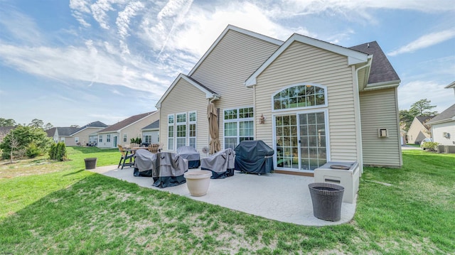 rear view of property featuring a yard and a patio area