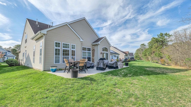 back of house featuring a lawn and a patio