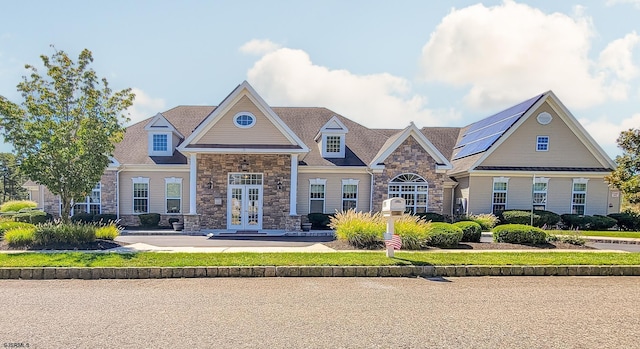 craftsman house featuring stone siding and french doors