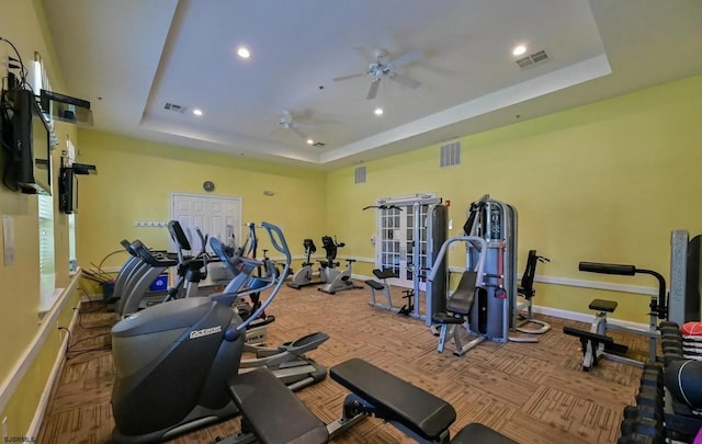 workout area with recessed lighting, a ceiling fan, visible vents, and a raised ceiling