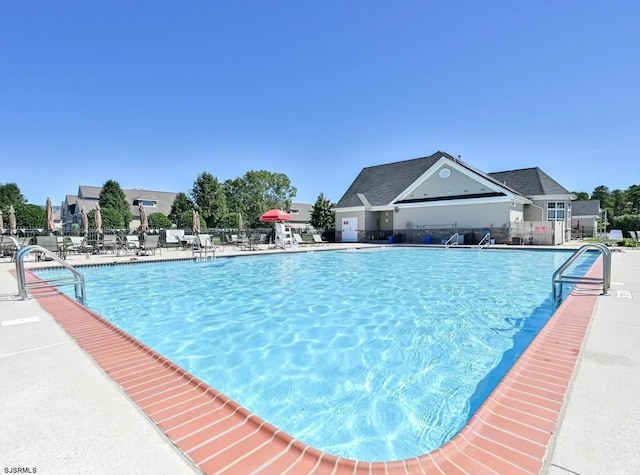 community pool with fence and a patio