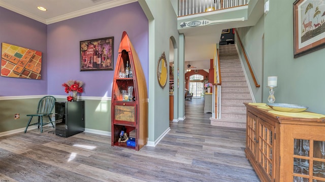 interior space featuring arched walkways, wood finished floors, and baseboards