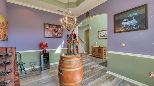 interior space featuring visible vents, baseboards, wood finished floors, and arched walkways