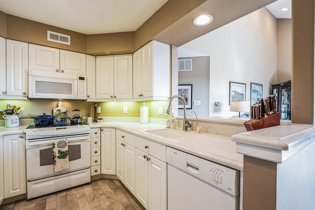 kitchen featuring visible vents, recessed lighting, white appliances, and a sink