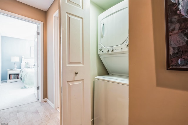 washroom with stacked washer / drying machine and laundry area