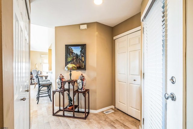 interior space featuring visible vents, light wood-style flooring, and baseboards
