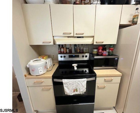 550 Central Ave Unit C4, Linwood, NJ 08221 - kitchen with appliances with stainless steel finishes, under cabinet range hood, light countertops, and white cabinetry