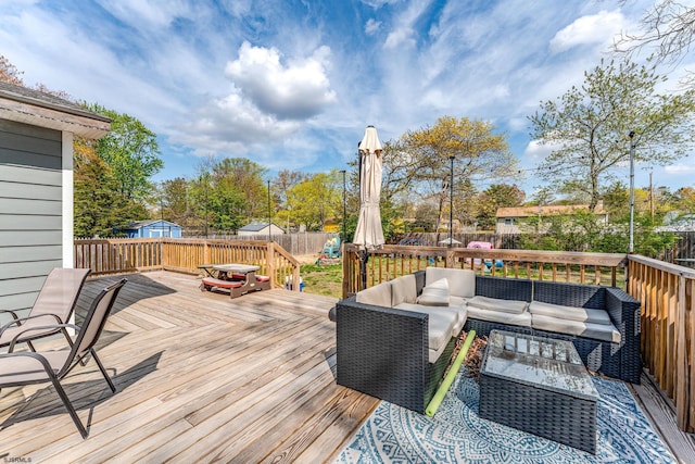 wooden deck featuring outdoor lounge area and a fenced backyard
