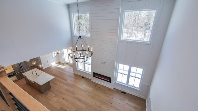1535 Bear Branch Ct, Vineland, NJ 08362 - living room with a fireplace, a notable chandelier, visible vents, a decorative wall, and wood finished floors