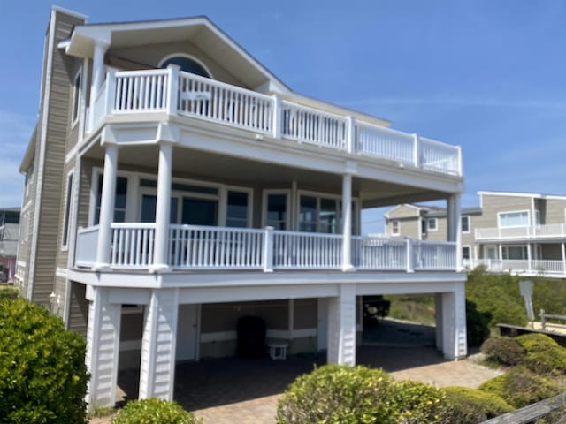 view of front facade with a carport and a balcony