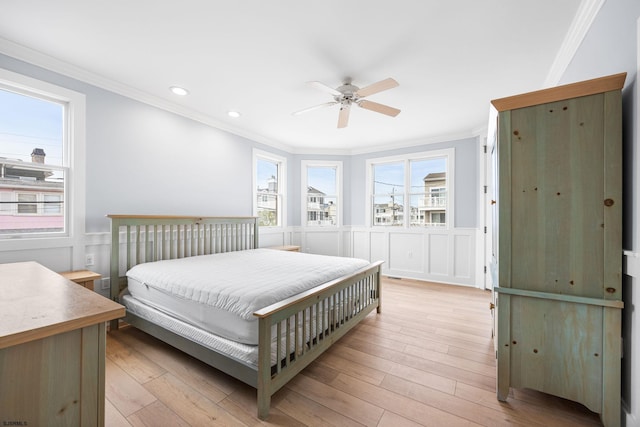 bedroom with ornamental molding, recessed lighting, wainscoting, and light wood-type flooring