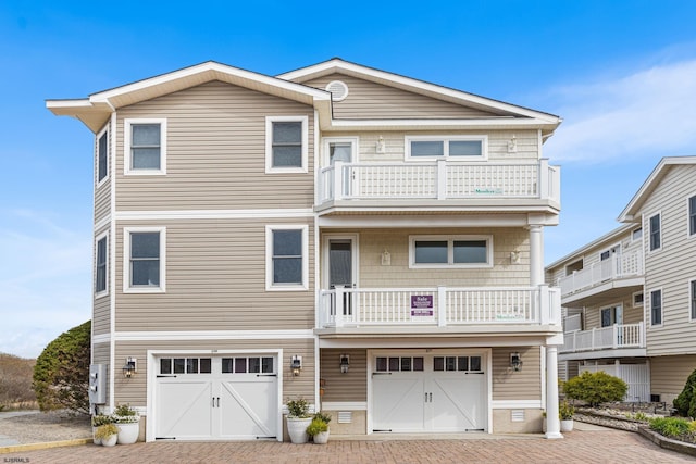 view of front facade with driveway, a balcony, and an attached garage