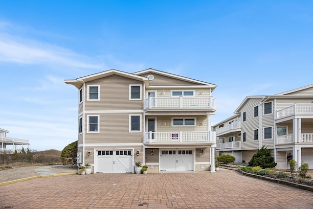 coastal inspired home with driveway, a garage, and a balcony