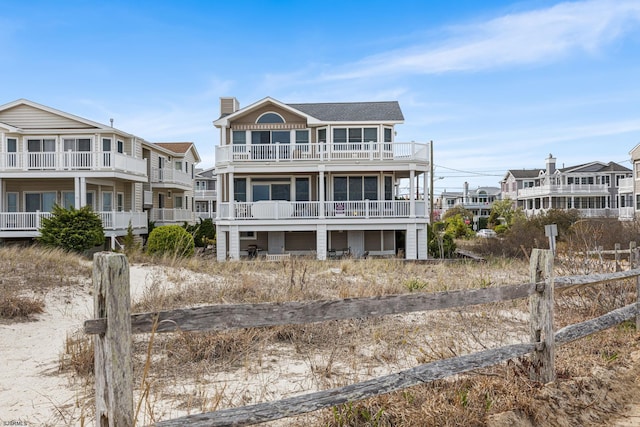 view of front of home with a chimney, a balcony, and a residential view