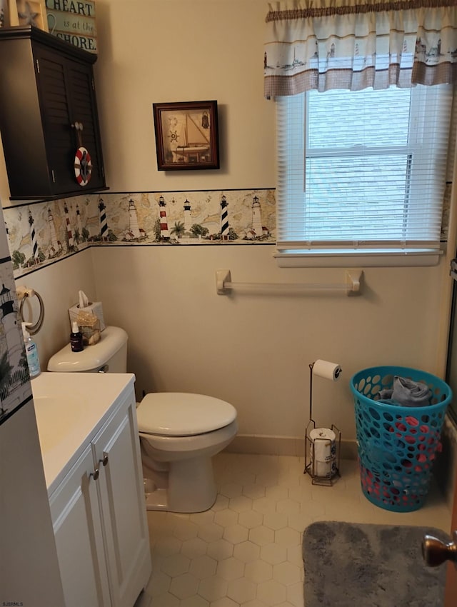 half bathroom with tile patterned floors, vanity, and toilet