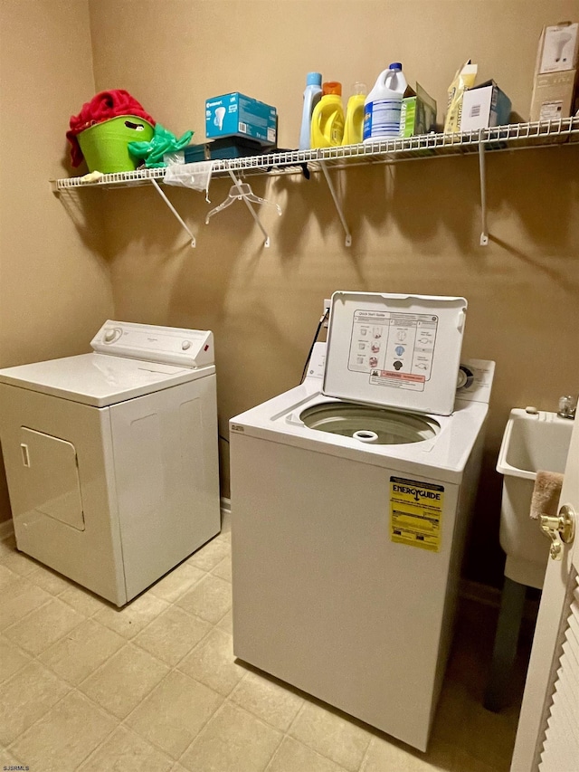 laundry room featuring a sink, washing machine and clothes dryer, and laundry area