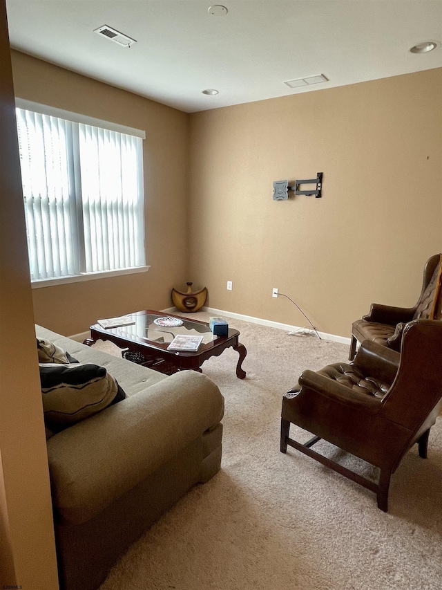 carpeted living area with baseboards and visible vents