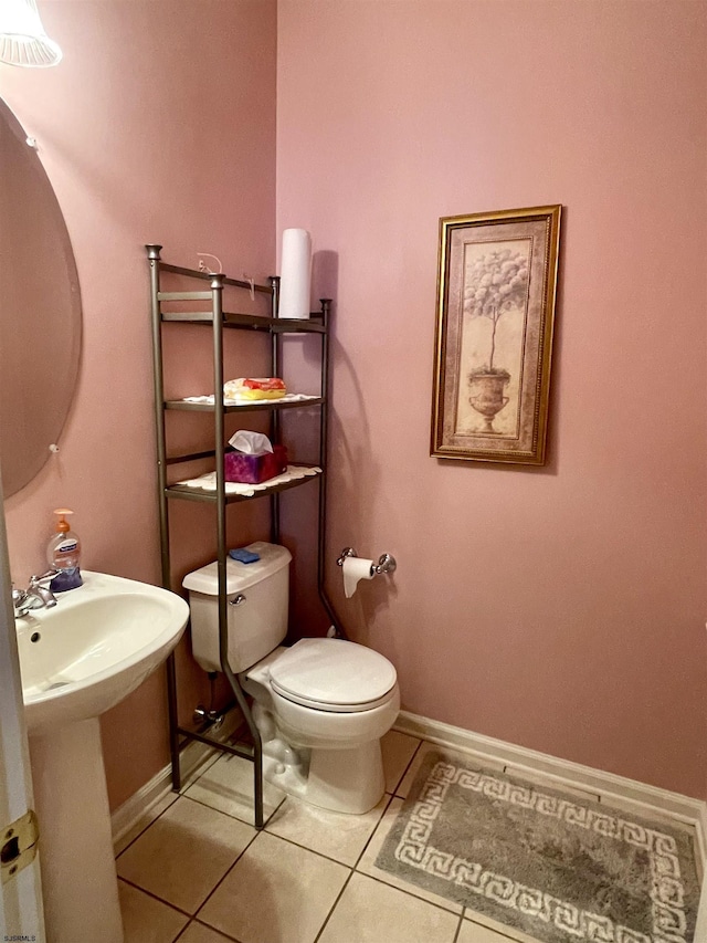 bathroom featuring toilet, tile patterned flooring, and baseboards
