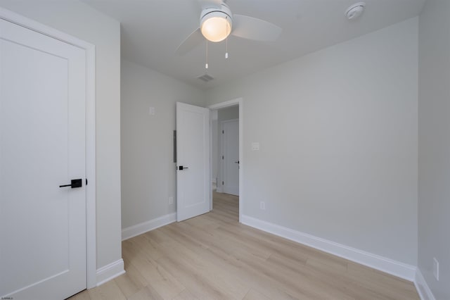 unfurnished bedroom with light wood finished floors, a ceiling fan, visible vents, and baseboards