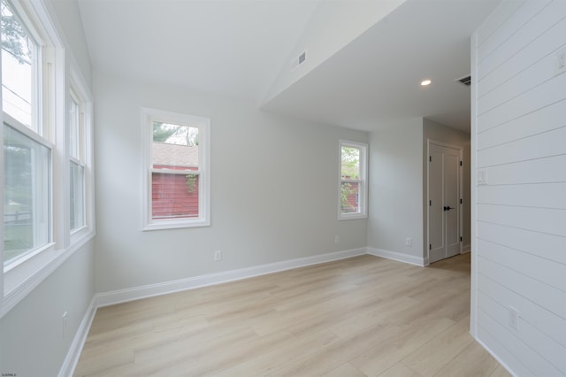 spare room featuring recessed lighting, baseboards, a wealth of natural light, and light wood-type flooring