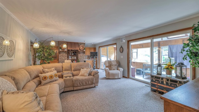 living area featuring visible vents, ornamental molding, a wealth of natural light, and light colored carpet