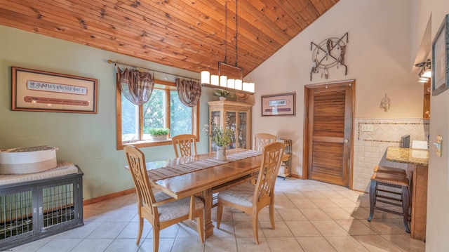 dining space featuring baseboards, wooden ceiling, light tile patterned flooring, and high vaulted ceiling
