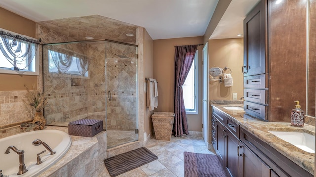 full bathroom with a bath, double vanity, a stall shower, and plenty of natural light