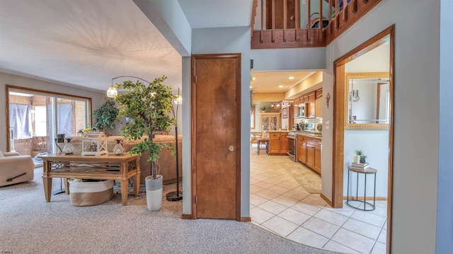 hallway with light carpet and light tile patterned flooring