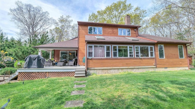 back of property with a lawn, a chimney, a deck, and an outdoor hangout area