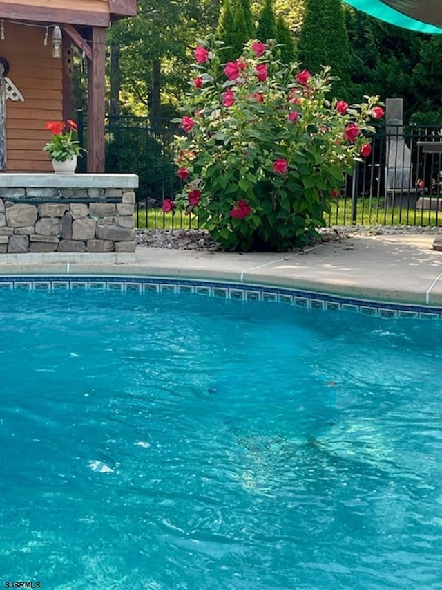 view of swimming pool featuring fence and a fenced in pool