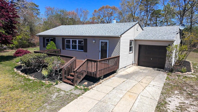 ranch-style house featuring a garage, a shingled roof, concrete driveway, and a deck