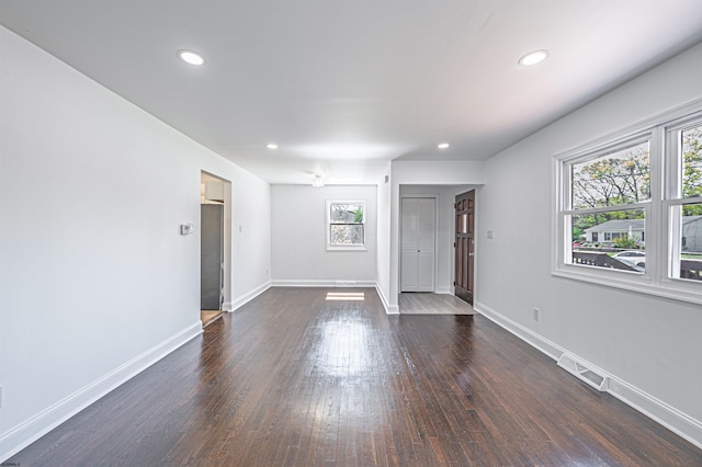 unfurnished living room with visible vents, baseboards, and a wealth of natural light