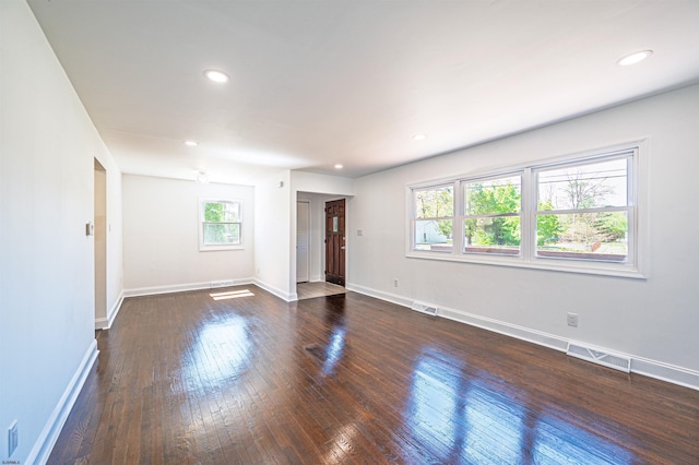 interior space featuring recessed lighting, baseboards, visible vents, and dark wood-type flooring